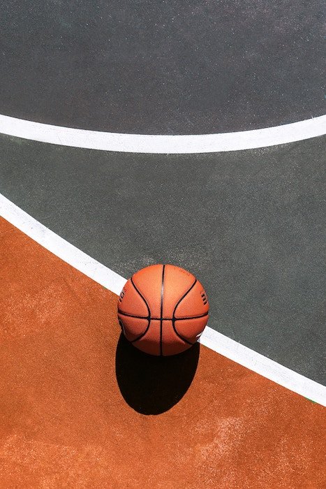Cool composition of a basketball resting on a court - basketball photography tips