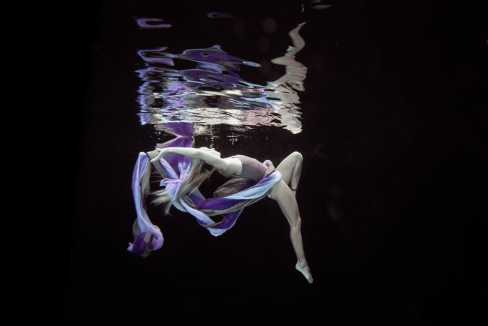 Atmospheric underwater photoshoot of a female model posing underwater