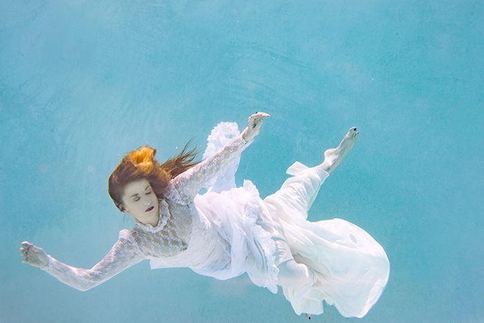ethereal underwater portrait of a female swimmer in a long, flowy dresses look 
