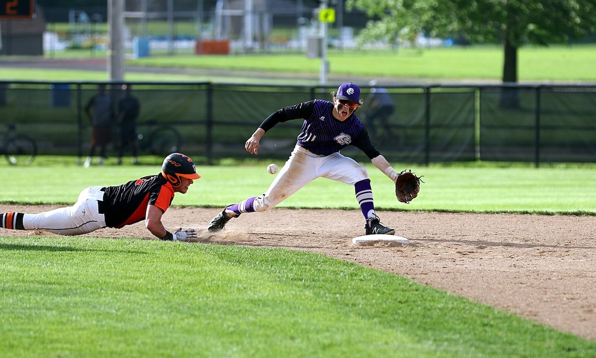 A baseball player tagging out a base runner diving back to a base asn an example of sports photography