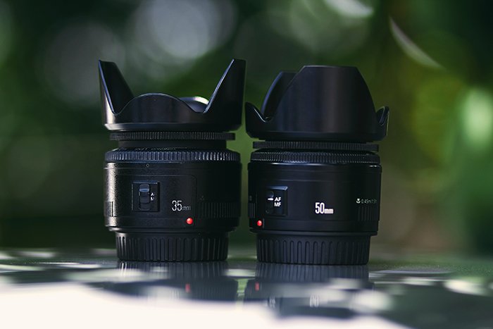 two camera lenses with lens hoods