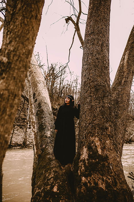 Cosplay photography of a female model in elf cosplay posing in a tree