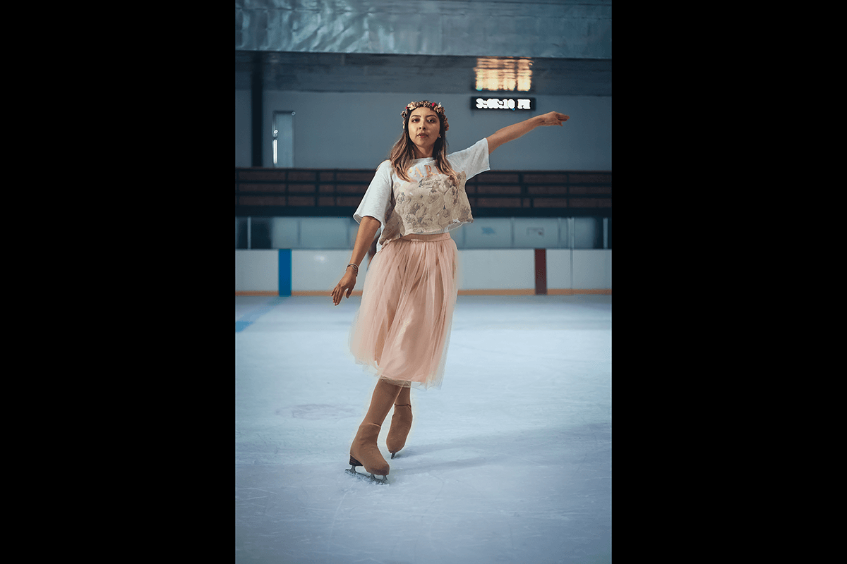Skater in a dress posing on the ice as an example of figure skating photography