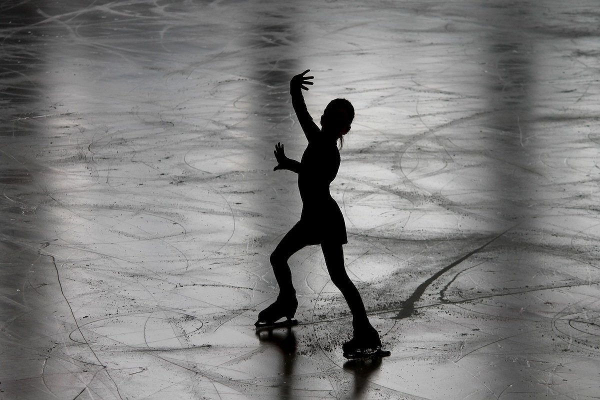 Silhouette of a figure skating posing on the ice as an example of figure skating photography