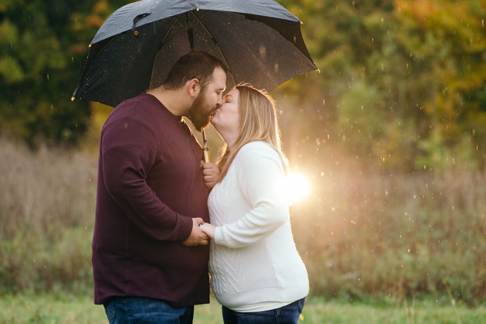 Outdoor portrait of a couple kissing under an umbrella