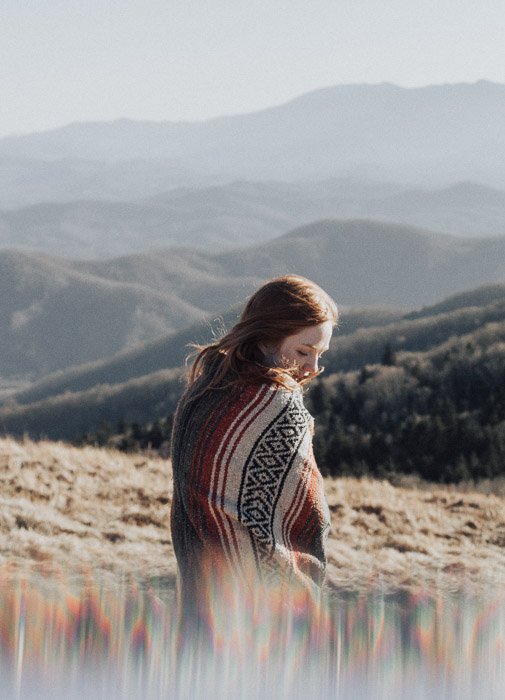 Artistic portrait of a femal model posing in a mountainous landscape taken using fractal filters 