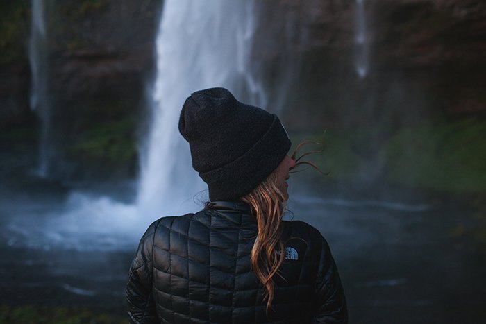 A female photographer in front of a waterfall in iceland