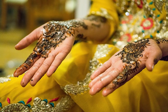 Beautiful wedding portrait of the decorated hands of an Indian bride posing in traditional costume - Indian wedding photography