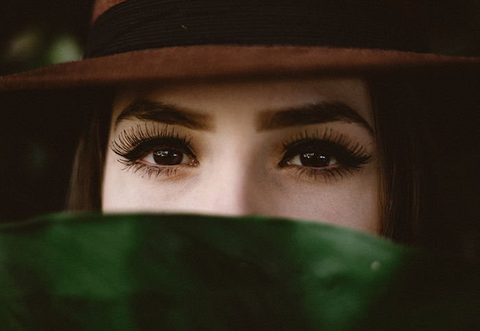 Striking portrait of a female model with fake eyelashes posing for a makeup photography shoot