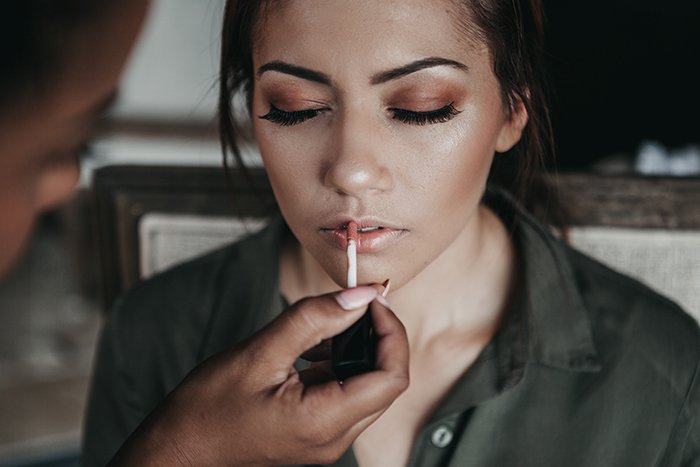 Portrait of a female model applying lipstick for a makeup photography shoot