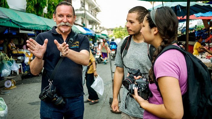 Three street photographers discussing on the street - camera club tips
