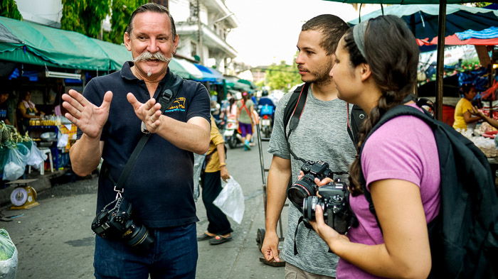 Three street photographers discussing on the street - camera club tips