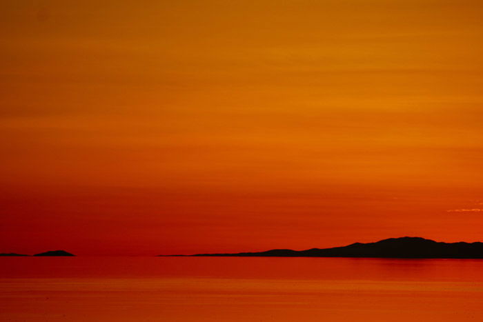 a beautiful orange and red colored coastal scene at sunset- stunning landscape photos 