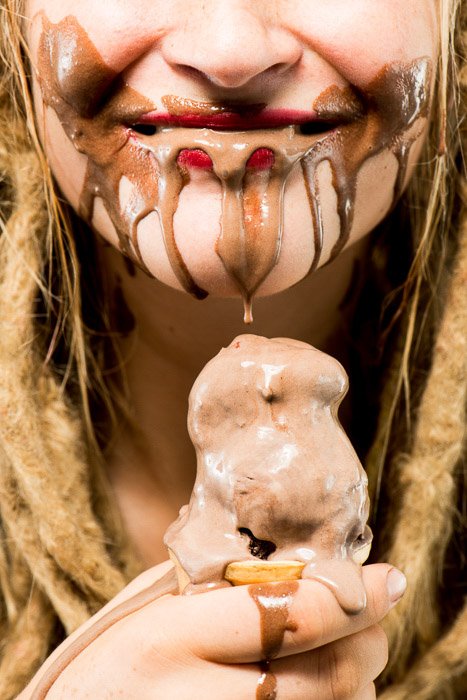 A closeup portrait of a female model eating chocolate ice-cream shot using softbox lighting