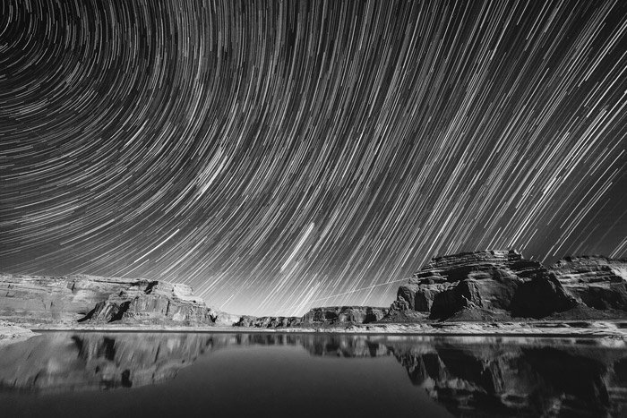 startrails over a rocky mountainous landscape shot in black and white - stunning landscape photos 