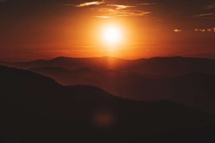 a glorious sunset over a mountainous landscape - stunning landscape photos 