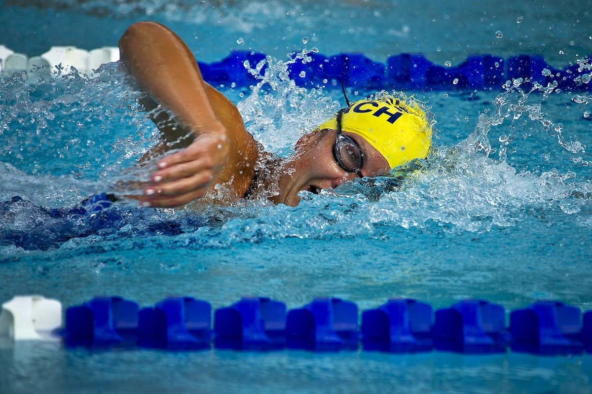 A close-up of a swimmer mid-stroke in a swimming pool as an example of sports photography