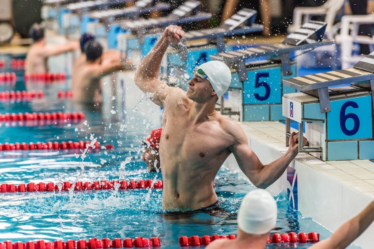 Male swimmer punching the air during a competition as an example of swimming photography