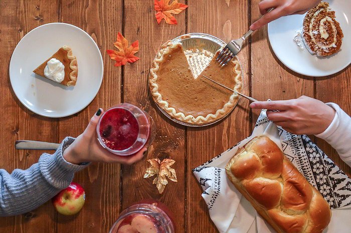 A thanksgiving photography flatlay featuring food and drinks on a wooden table