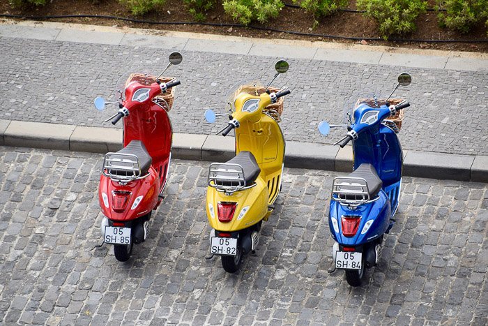 Aerial photo of red, yellow and blue scooters parked beside each other - triadic color scheme