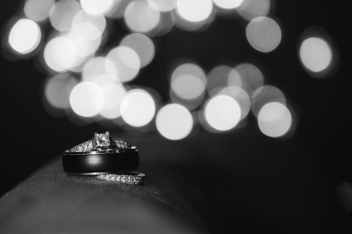a black and white photo of a wedding ring with bokeh background - wedding photography business