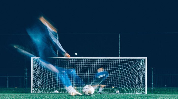 Artistic soccer photography shot of a blurry player on the field at night
