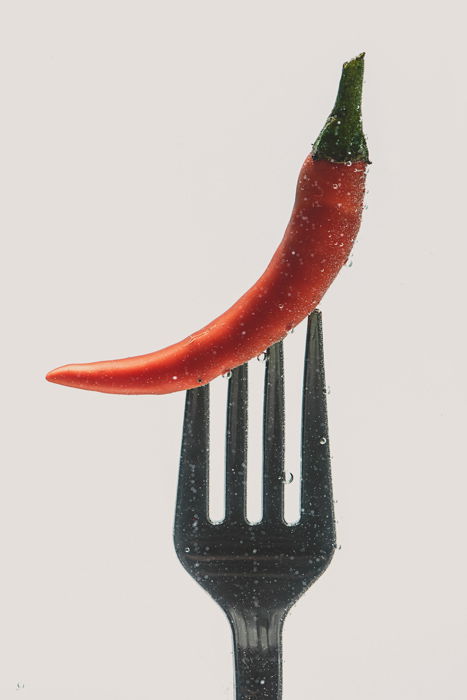 a chilli pepper on a fork - setup to shoot colorful paint in water photography