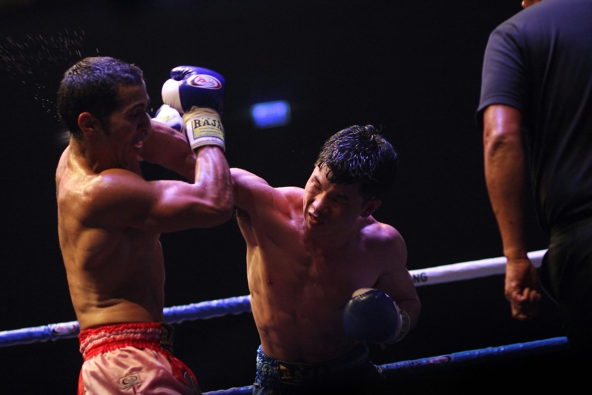 A boxer punching an opponent's face as an example of boxing photography