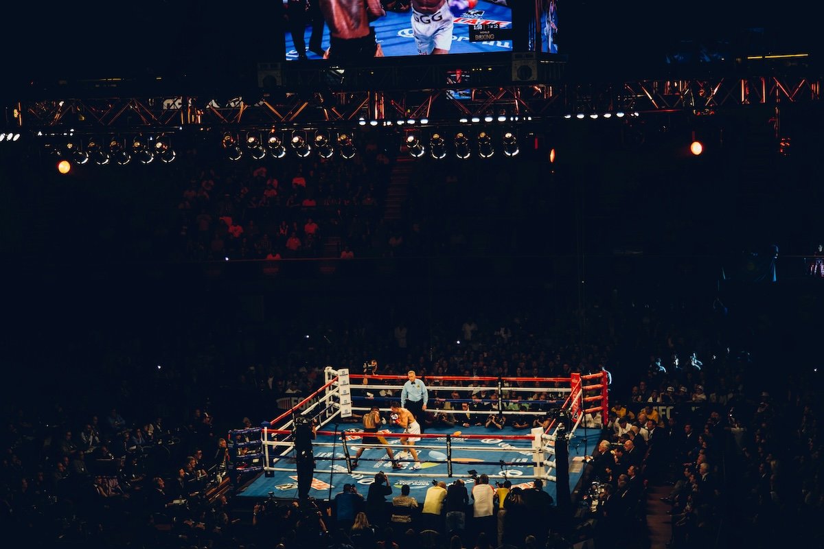 A wide view of a live match with two boxers in a ring from afar as an example of boxing photography