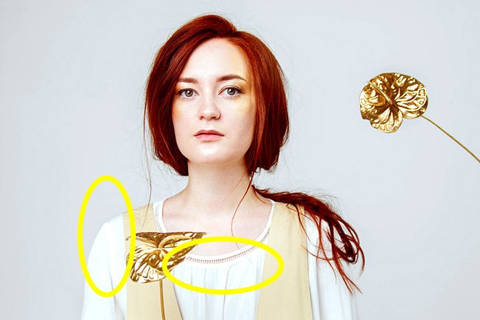 A studio portrait of a female model with highlights circled in yellow