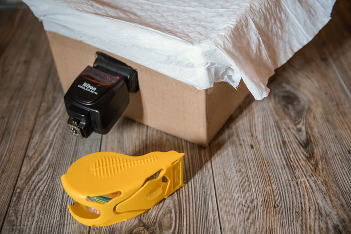 DIY photography lighting softbox made of cardboard and white cloth attached to a flash