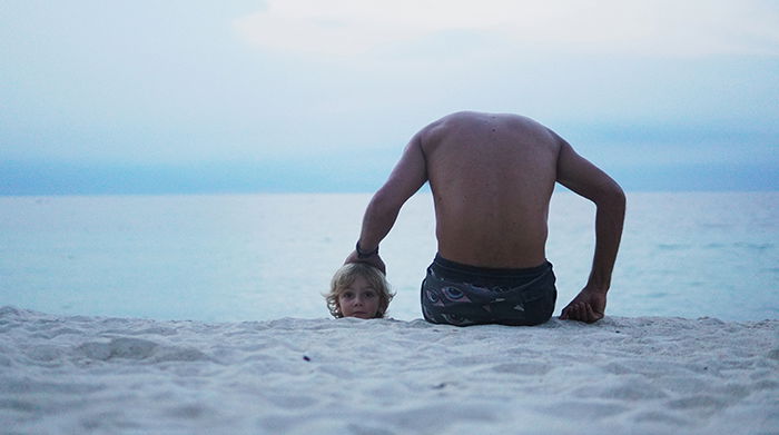 Funny photo of a seemingly headless man holding a childs head on the beach