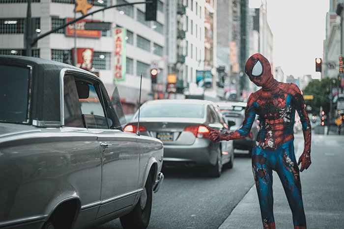 A funny photography portrait of spiderman hailing a cab