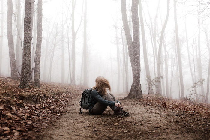 Atmospheric portrait of a girl sitting in a forest edited using Lightroom dehaze feature