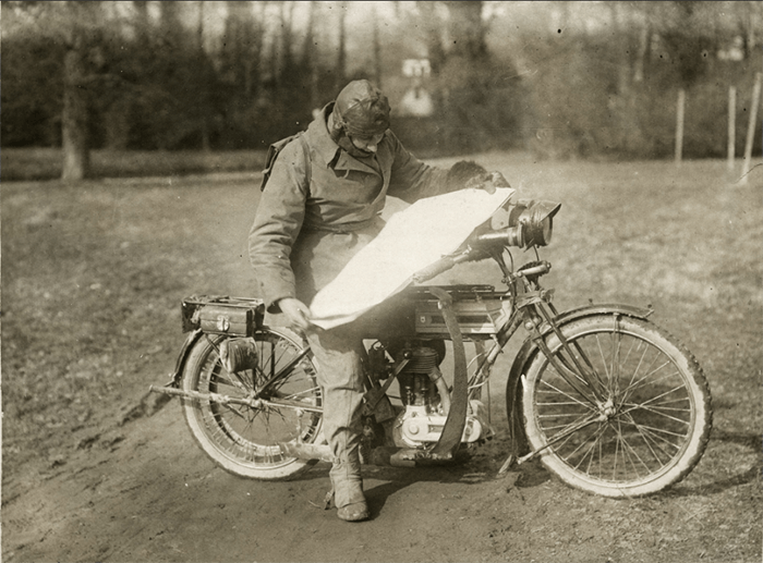 Old sepia toned photo of a man on a motor bike