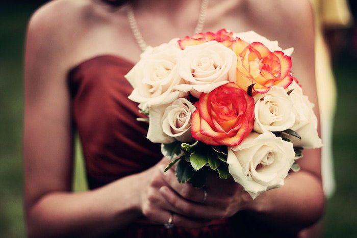 atmospheric close up wedding portrait of a bridesmaid holding a bouquet 