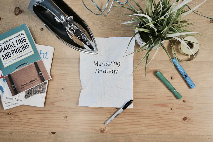 flatlay of a photography business marketing plan, stationary and plants