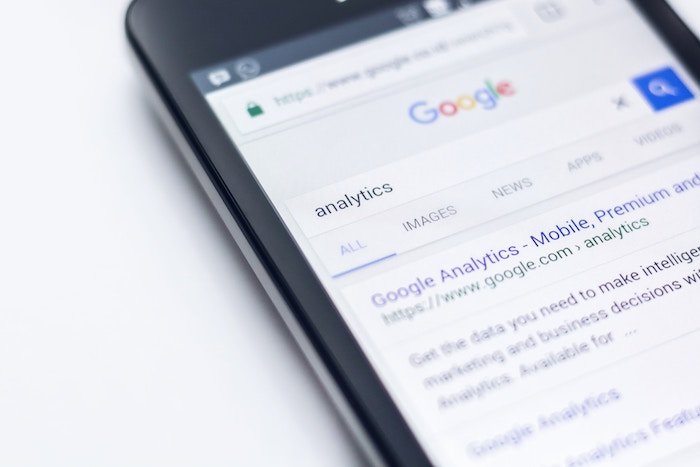 a close up of a smartphone screen with 'analytics' typed in google for seo photography