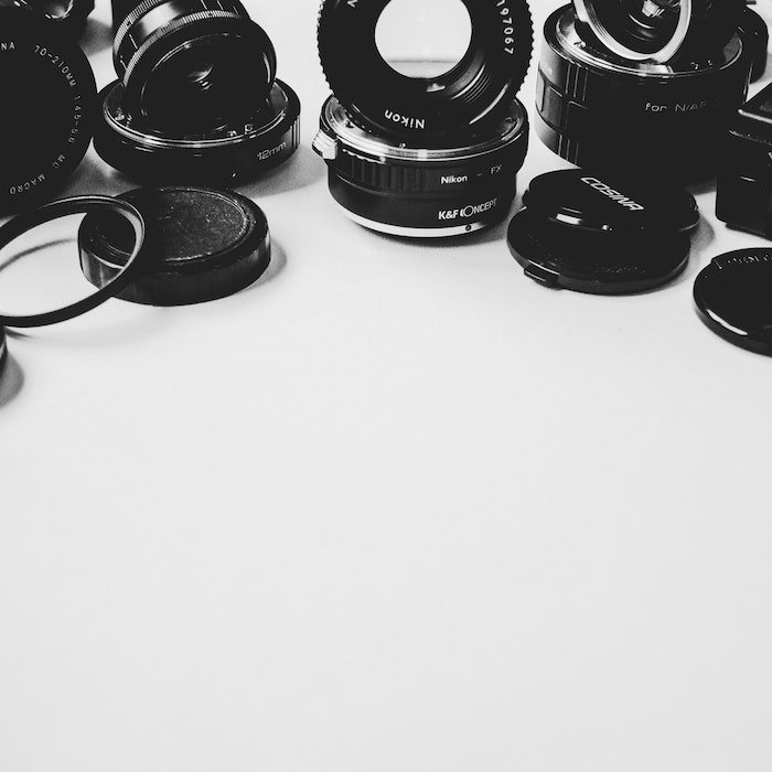 a still life of different lenses and lens caps - best lens for product photography