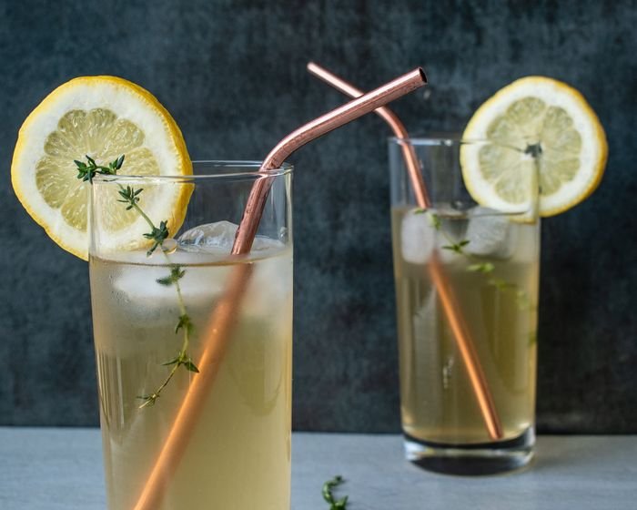 a photo of two glasses of lemonade with ice cubes and straws