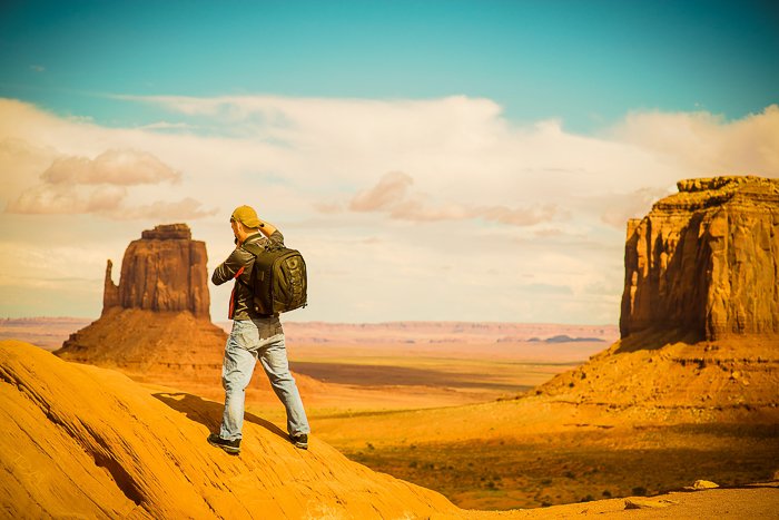 a hiker standing on a rocky desert landscape - adventure photography skills