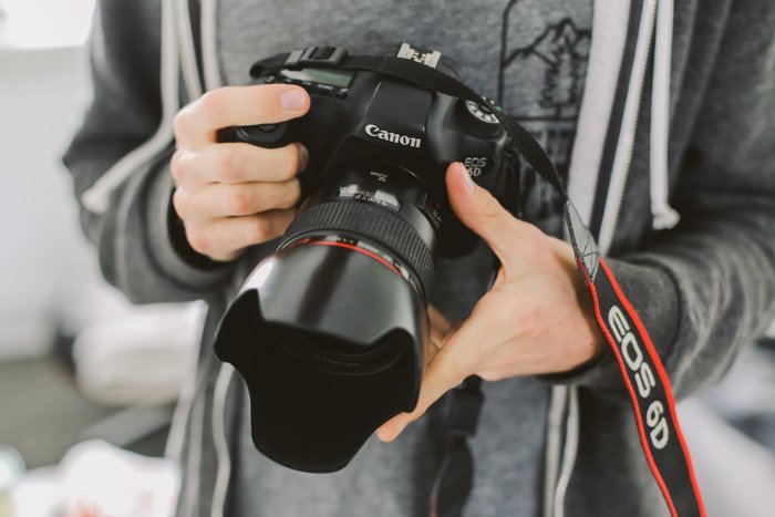 finding camera manuals online: a photographer holding a canon dslr 