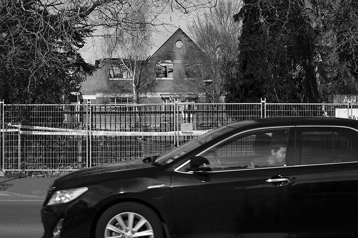 candid street photography of a car driving by an old building