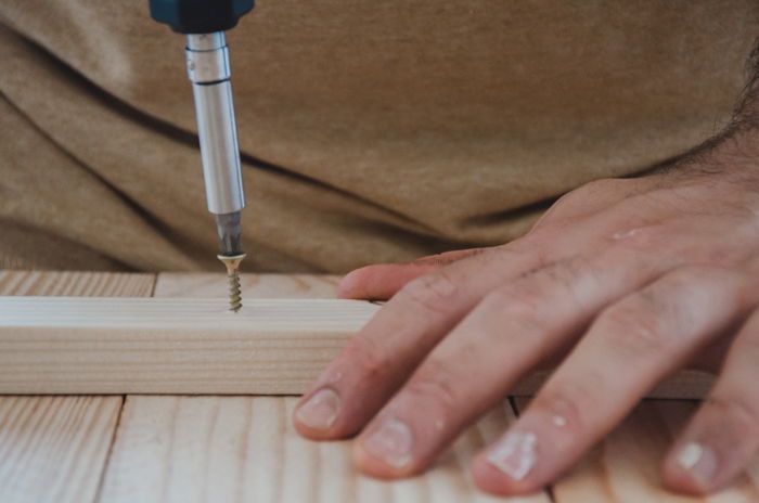 a person making a DIY wood backdrop for photography