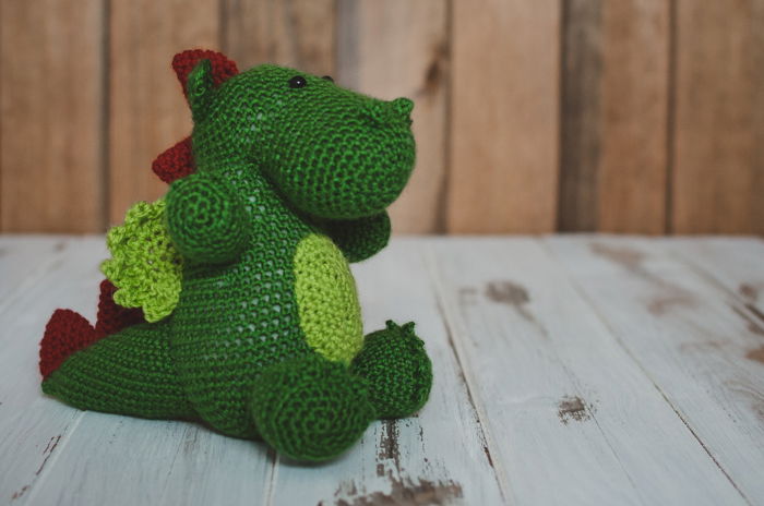 a childs dinosaur soft toy on a DIY wood backdrop 