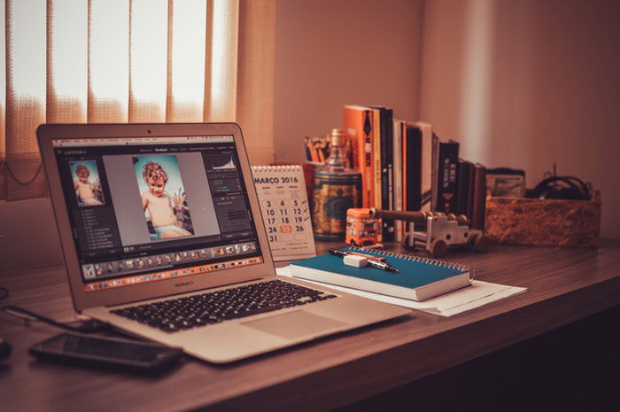 a laptop open on an editing screen in an home office 