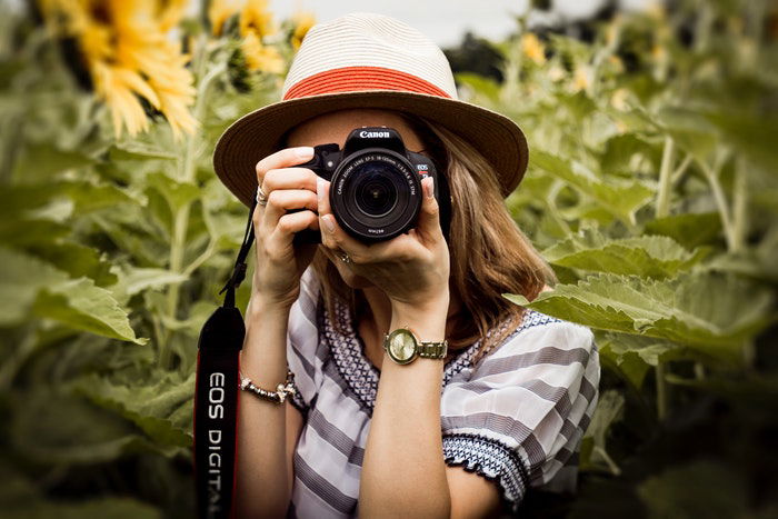 A female photographer pointing her canon DSLR