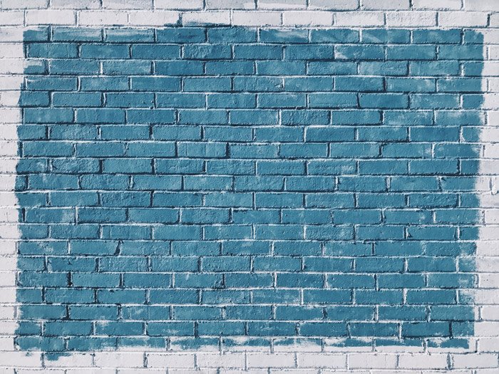 Uma parede de tijolos texturizados pintados de azul e branco - geometria de composição