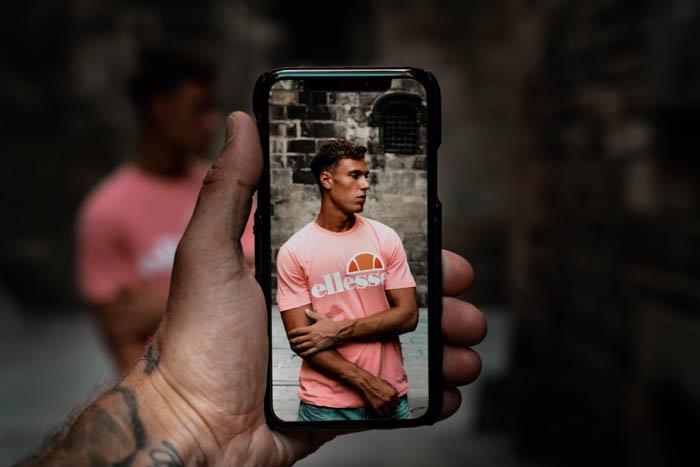 a person shooting a street portrait with a smartphone- iphone vs android camera