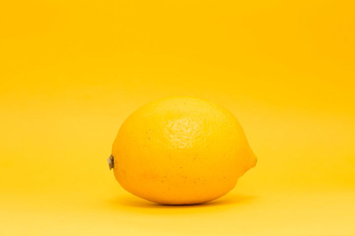 a lemon on yellow background - symbolism in photography